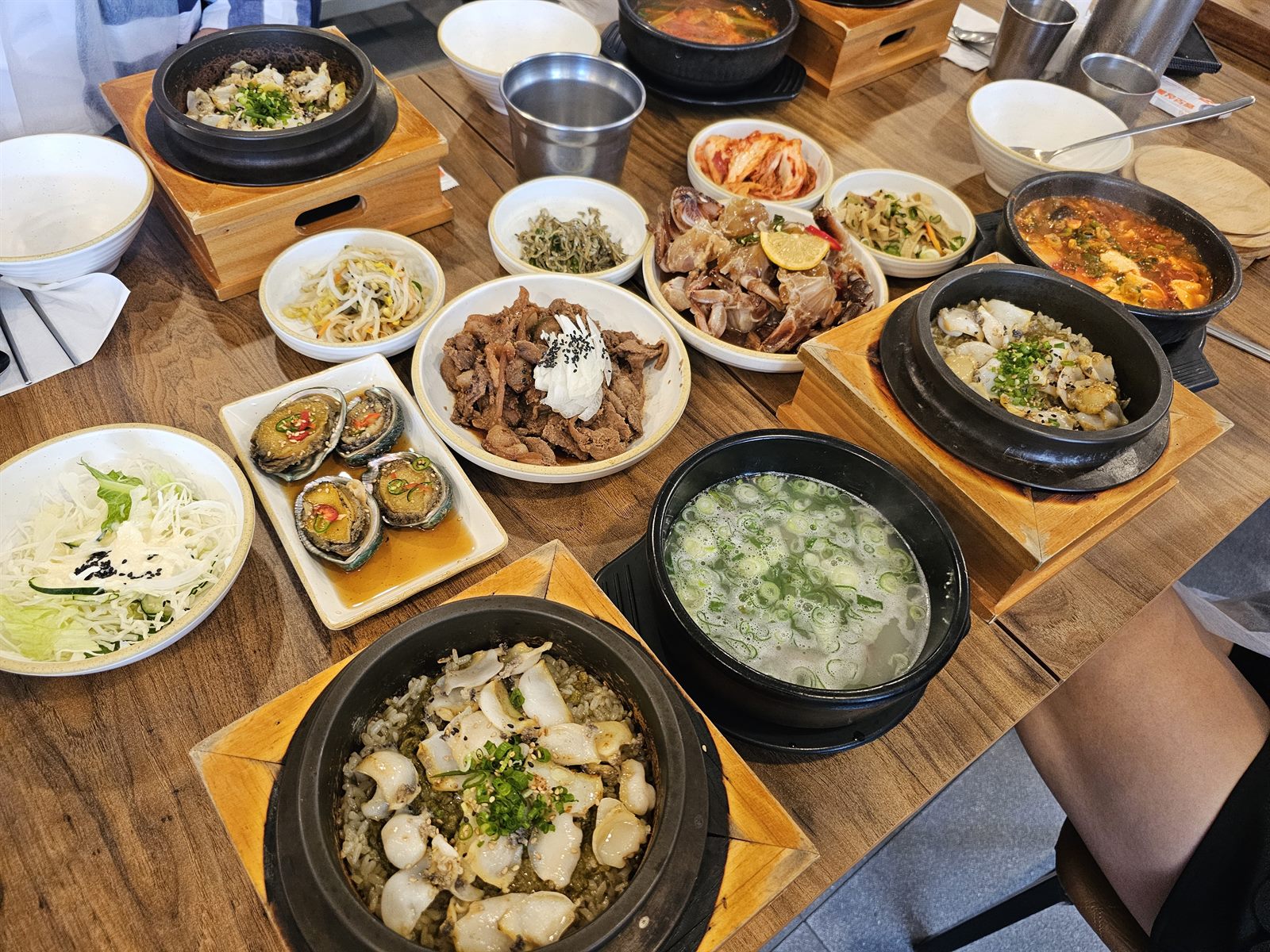 장모식탁에서 받은 한 상 — 전복솥밥과 맑은 국, 붉은 찌개, 간장게장, 전복장, 제육볶음, 샐러드와 밑반찬이 나무 상 위에 차려져 있습니다