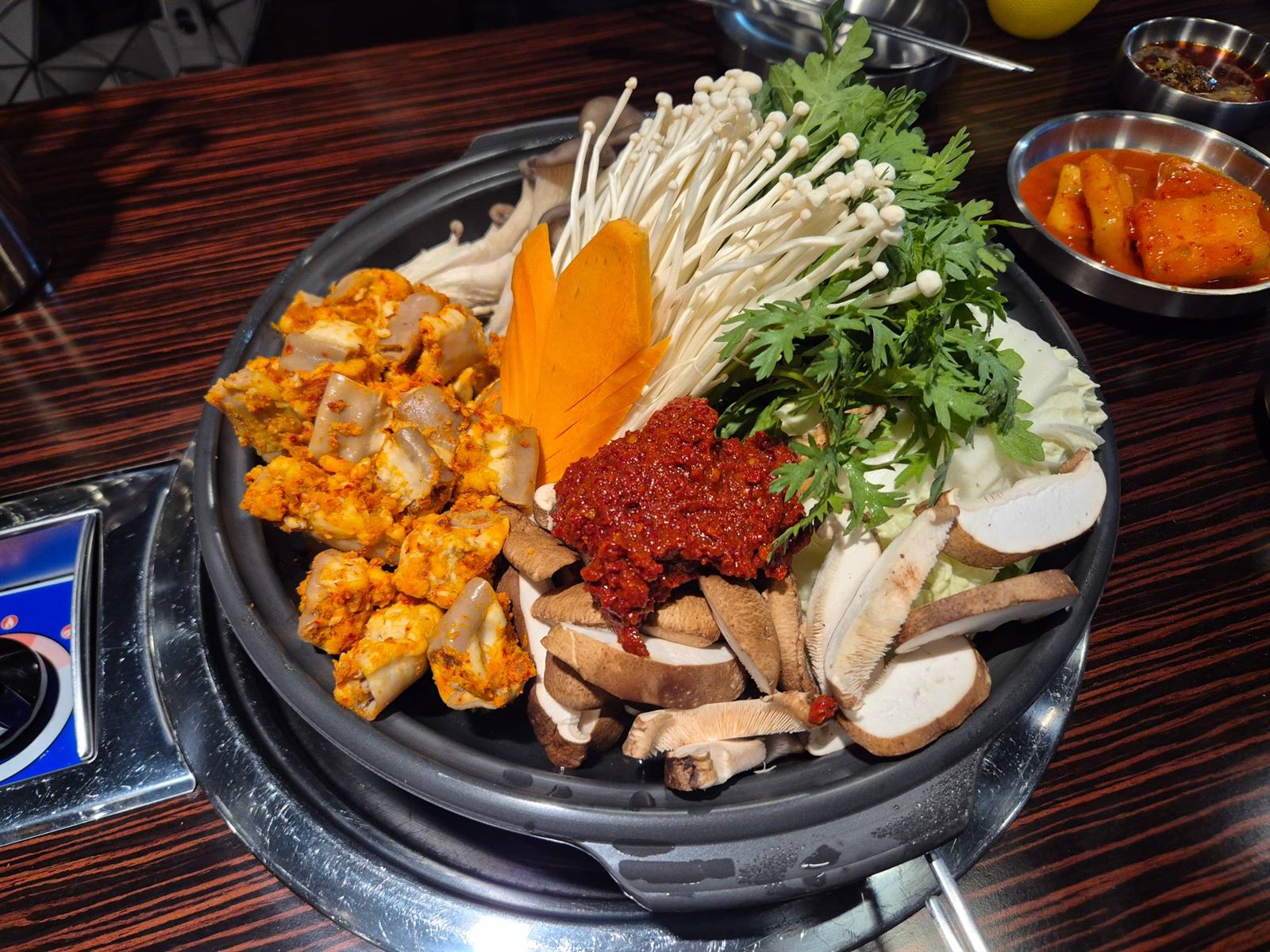 중앙해장의 소곱창전골 재료 — 소곱창과 표고버섯·팽이버섯·쑥갓·당근·양념장이 한 상에 올라갑니다